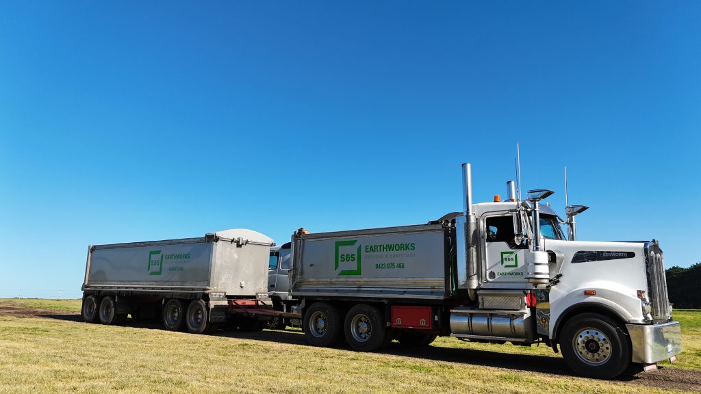 "909 Kenworth truck parked at a S&S Earth Works construction site"